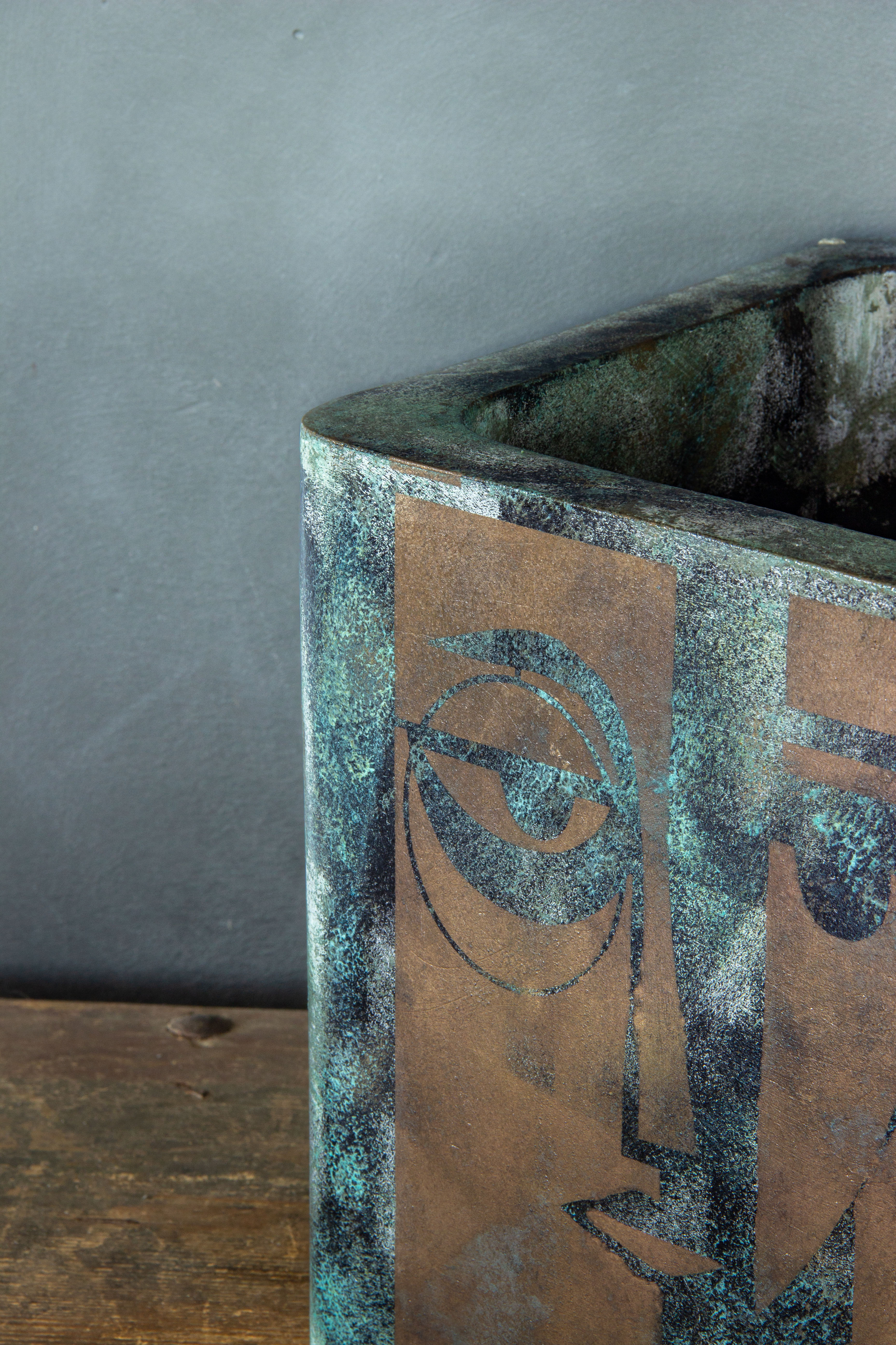 Osłonka z artystycznym motywem twarzy, efekt kortenu z turkusową patyną, ręcznie wykonana